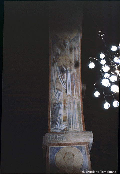 Fresco, south aisle, third arch, east intrados showing Saint?