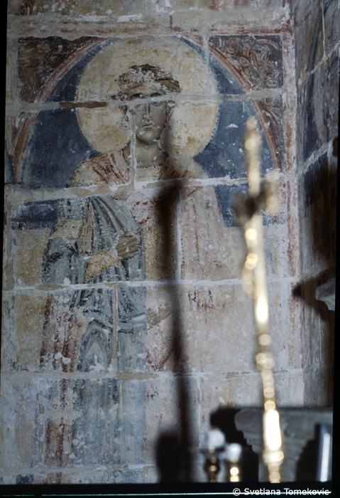 Fresco, north wall, east corner, showing first saint from the east (fourth saint from the west)