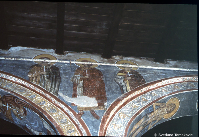 Fresco, nave, north aisle, south wall, east end, spandrel and above arch, showing three martyrs