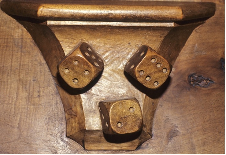 Misericord of three carved dice suggesting Game of Dice or Instrument of the Passion, 15c. Cathedral of Saint-Jean-de-Maurienne in France. Image: Elaine C. Block Database of Misericords.