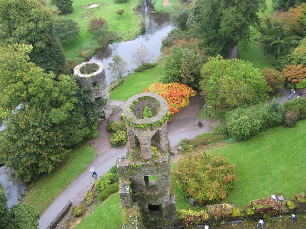 View of castle structures from above, in a landscape with a small river.