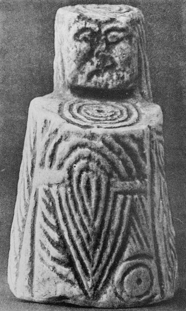 A chess piece incised with ornament and a human face.