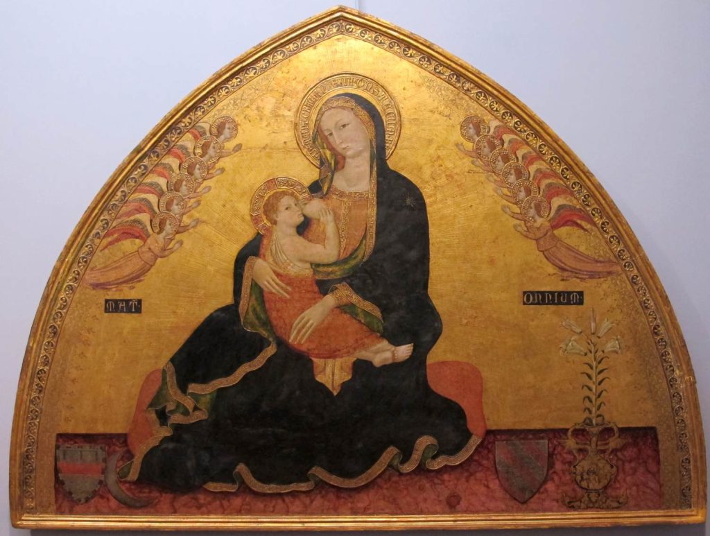 An arched gold panel with a painting of the Virgin Mary as a woman seated on a cushion, holding a child in her lap and flanked by small flying angels.